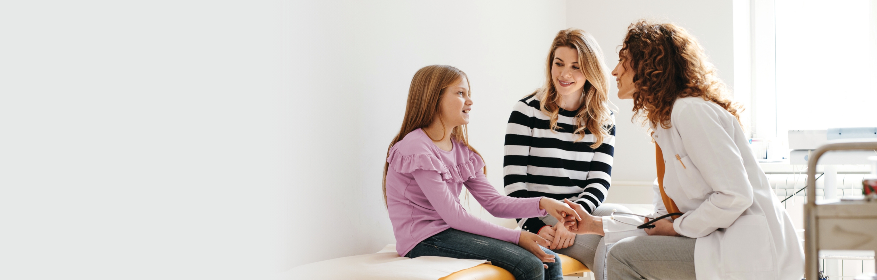 girl with mother speaking to female provider