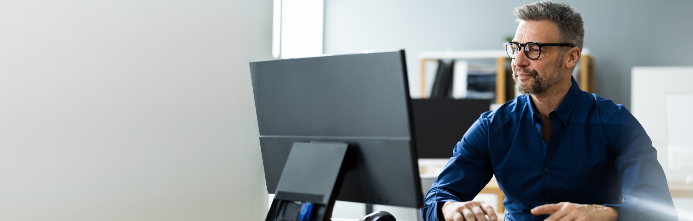 Man sitting at desk looking at computer monitor