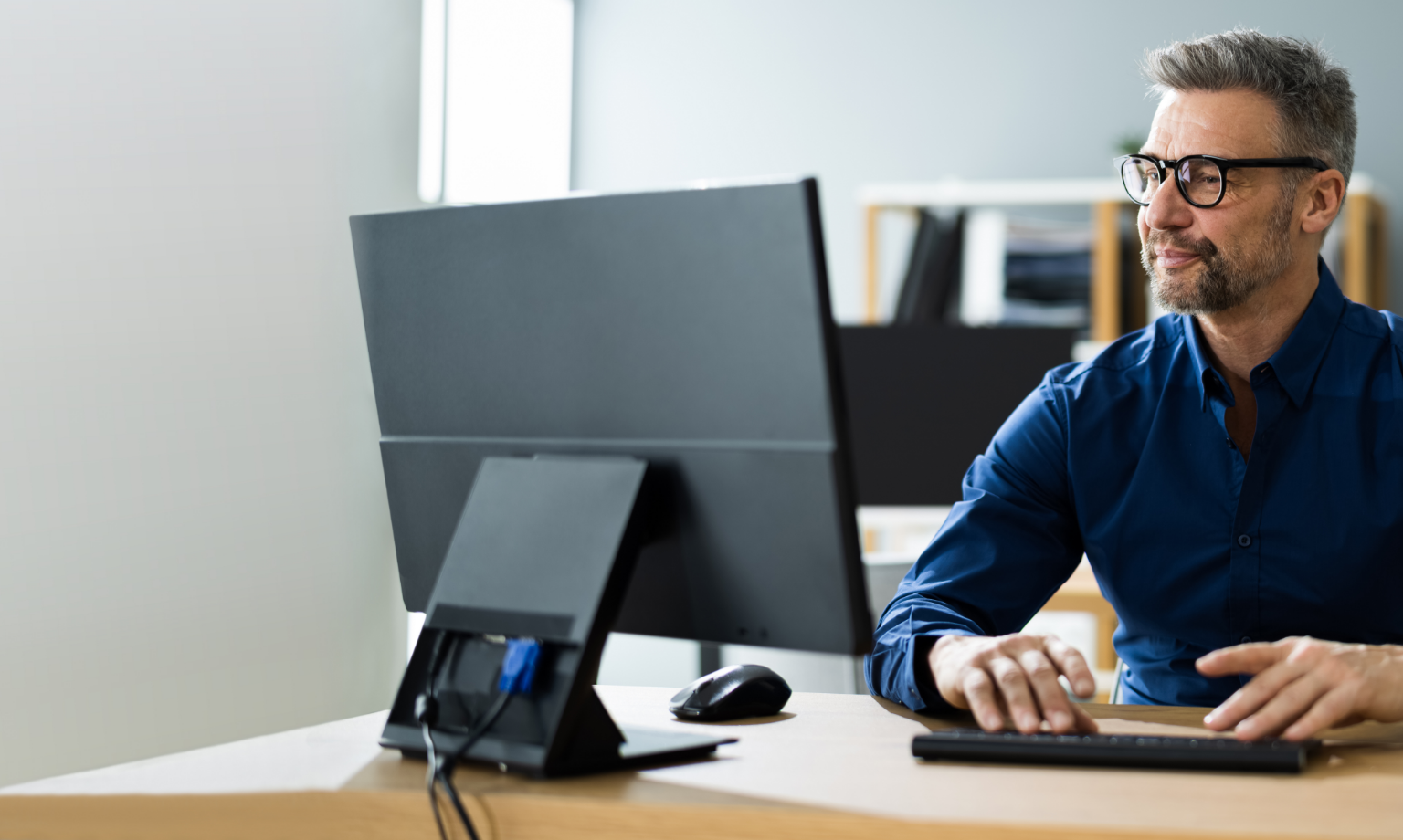 Man sitting at desk looking at computer monitor