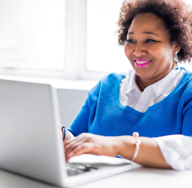 happy woman looking at laptop