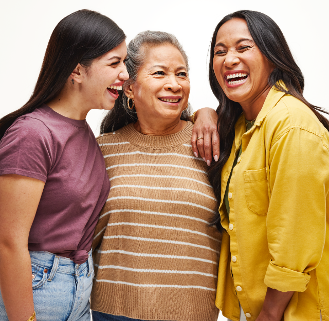 Three women hear each other laugh together - helping illustrate the UnitedHealthcare commitment to meeting patients' hearing health care needs