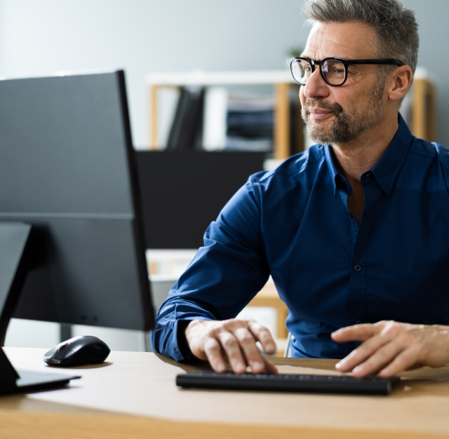 Man sitting at desk looking at computer monitor