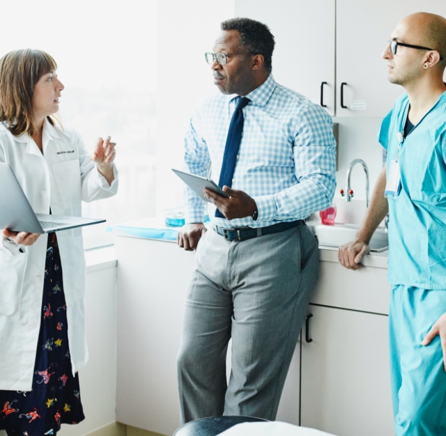 three healthcare professionals talking to each other