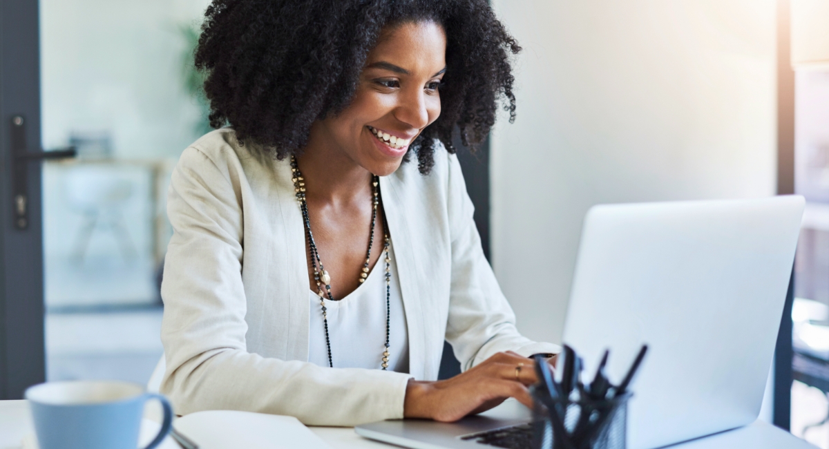 woman sitting at a desk looking at a laptop screen